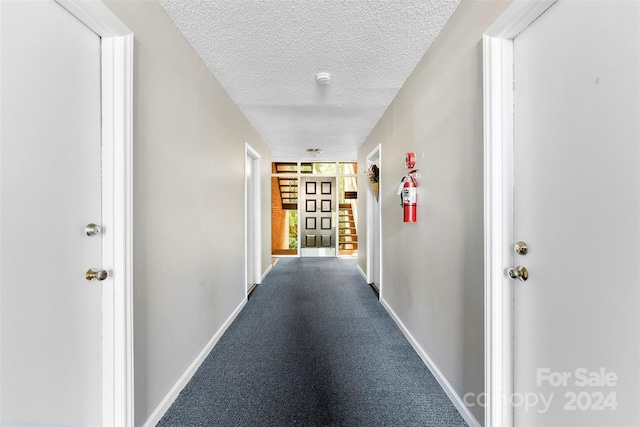 hall featuring a textured ceiling