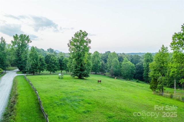 view of property's community with a rural view and a lawn