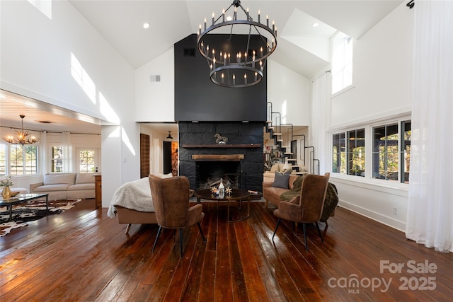 living room with hardwood / wood-style floors, plenty of natural light, a tile fireplace, and a high ceiling