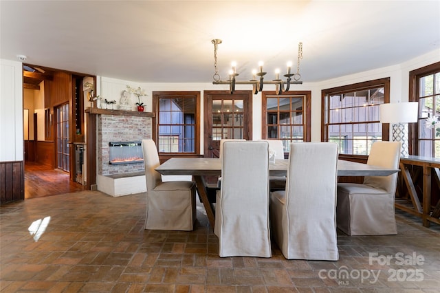 dining space with an inviting chandelier and a fireplace