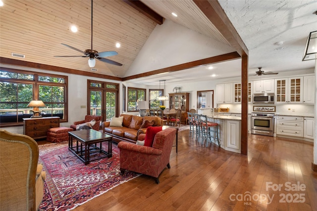 living room with high vaulted ceiling, dark hardwood / wood-style floors, beam ceiling, and plenty of natural light