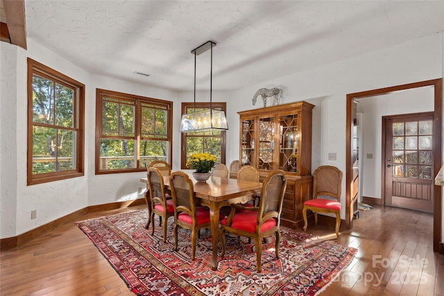 dining area featuring hardwood / wood-style floors and a textured ceiling