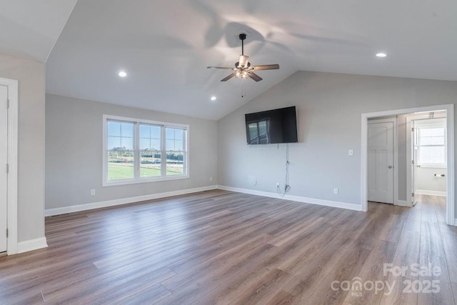 unfurnished living room with lofted ceiling, plenty of natural light, and light wood-style flooring