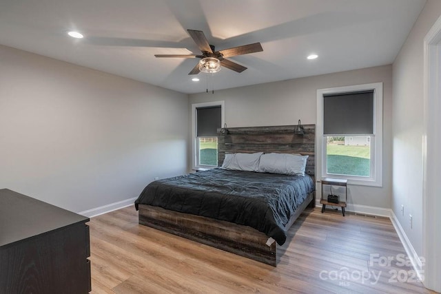 bedroom with light wood-style floors, baseboards, and recessed lighting