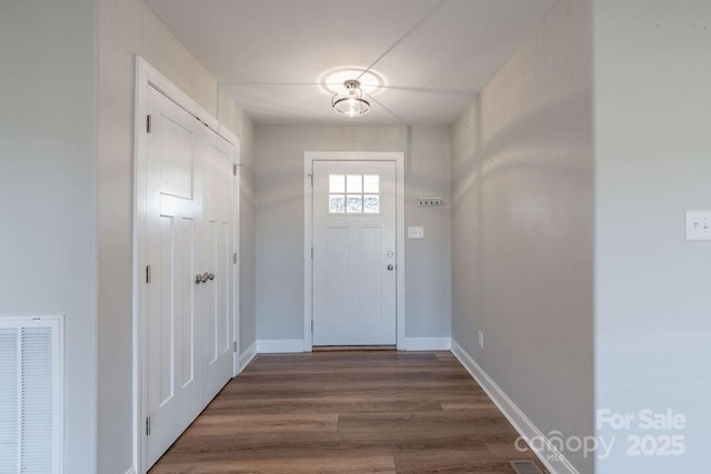 entryway with baseboards, visible vents, and dark wood finished floors