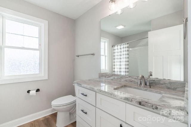 full bathroom featuring toilet, a shower with shower curtain, wood finished floors, vanity, and baseboards