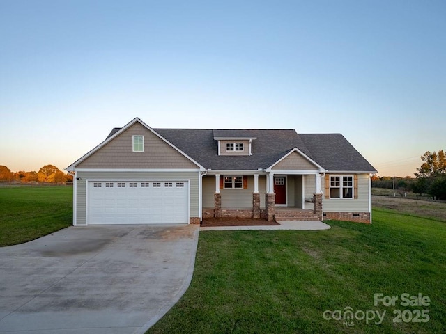 craftsman house featuring a yard, covered porch, concrete driveway, an attached garage, and crawl space