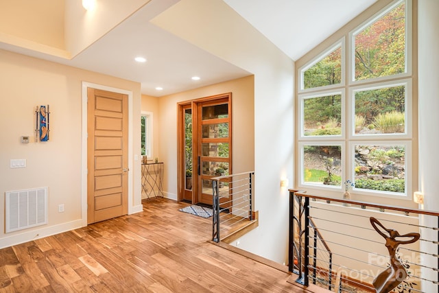 interior space with vaulted ceiling and light hardwood / wood-style flooring