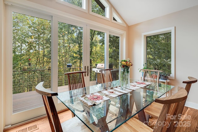 sunroom featuring visible vents, vaulted ceiling, and french doors