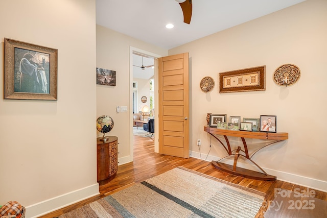 hallway featuring recessed lighting, baseboards, and wood finished floors