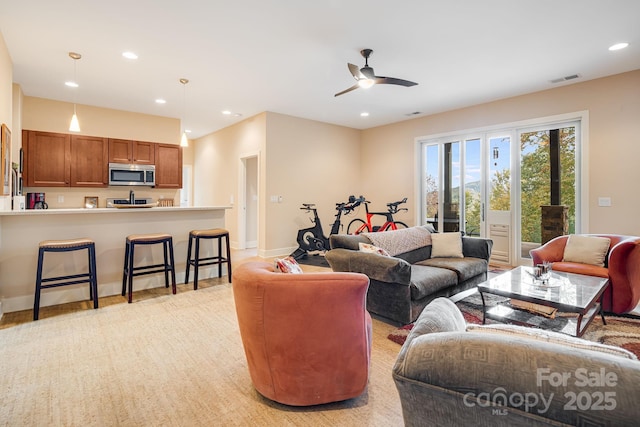 living area with baseboards, visible vents, a ceiling fan, and recessed lighting