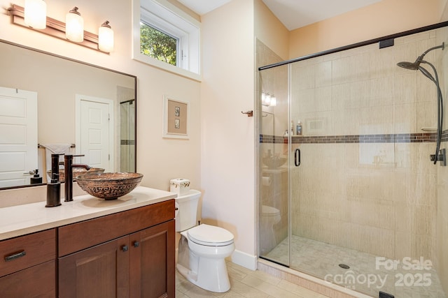 bathroom with vanity, tile patterned flooring, a shower with door, and toilet