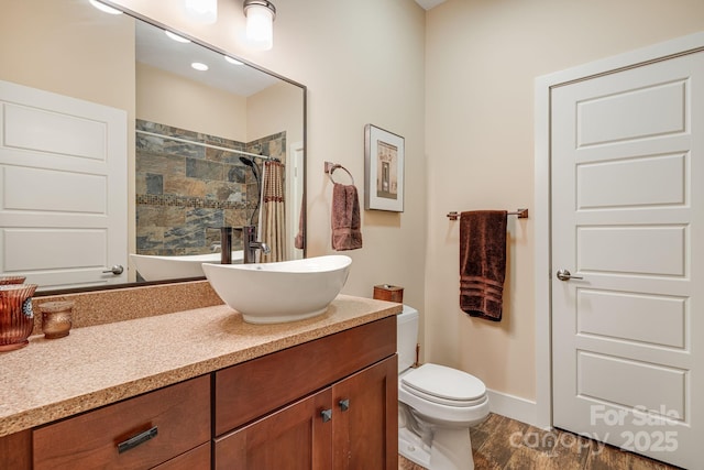 bathroom with vanity, toilet, a shower with shower curtain, and hardwood / wood-style floors