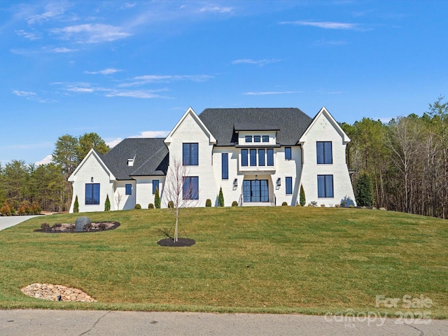 modern inspired farmhouse with a shingled roof and a front yard