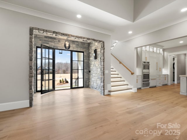 interior space featuring recessed lighting, stairway, baseboards, and light wood-style floors