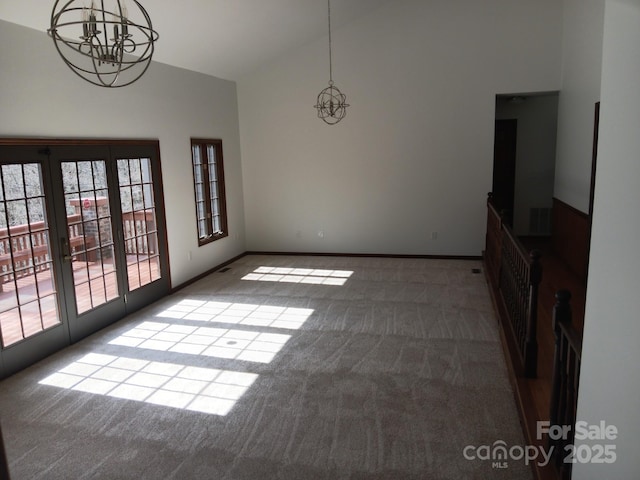 unfurnished dining area featuring carpet, high vaulted ceiling, and a notable chandelier