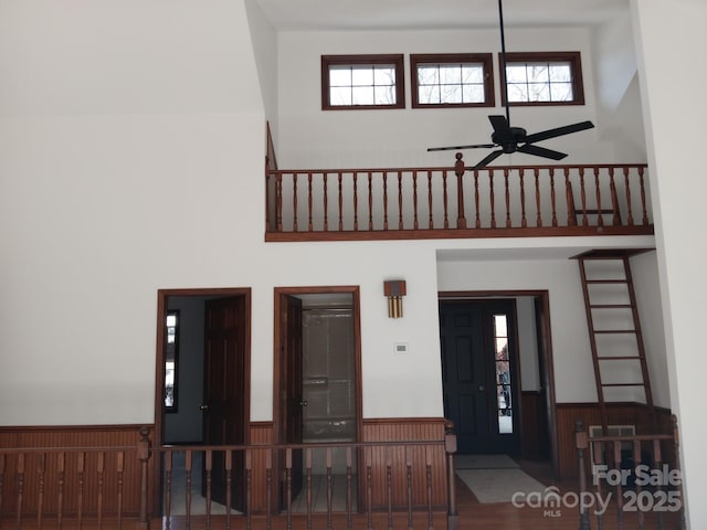 foyer entrance featuring ceiling fan and a high ceiling