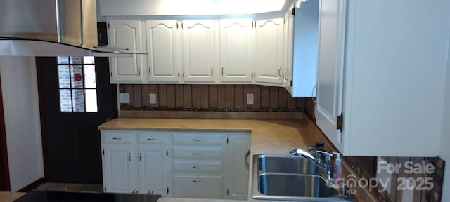 kitchen with sink, white cabinets, and extractor fan