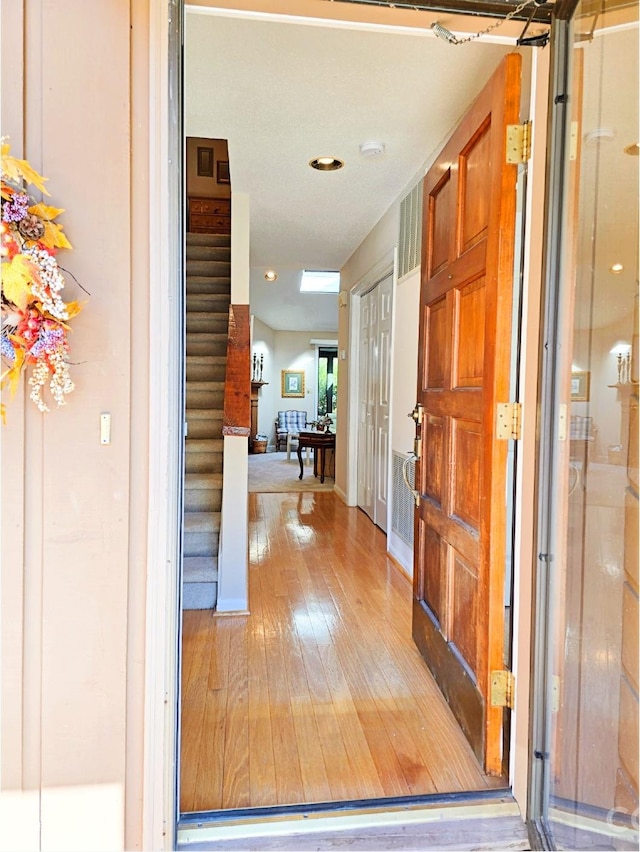 interior space featuring light wood finished floors, stairway, and baseboards