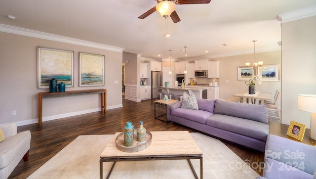 living room with dark wood-type flooring, crown molding, and ceiling fan with notable chandelier