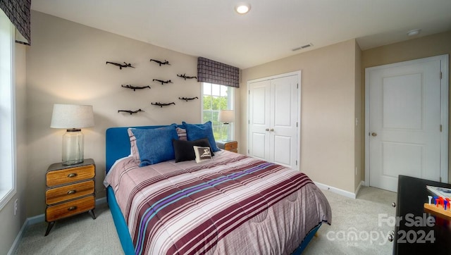 bedroom featuring light carpet and a closet