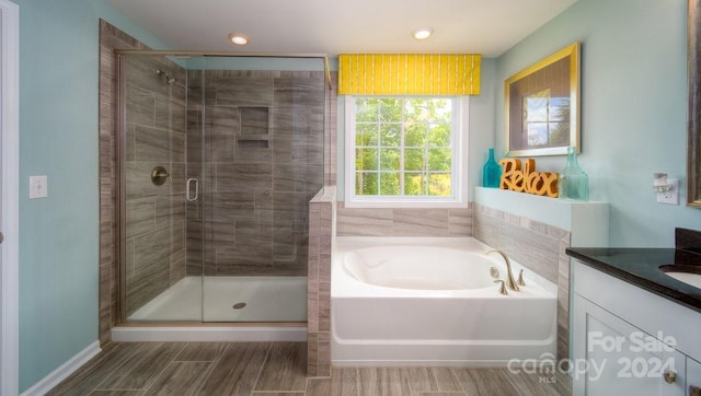 bathroom featuring vanity and independent shower and bath