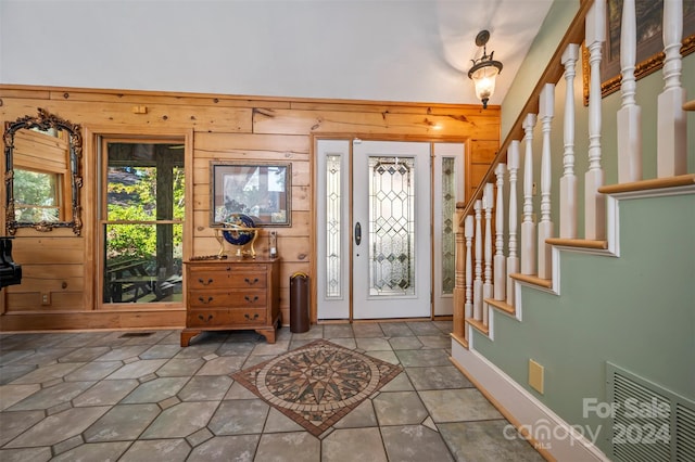 foyer entrance featuring wood walls