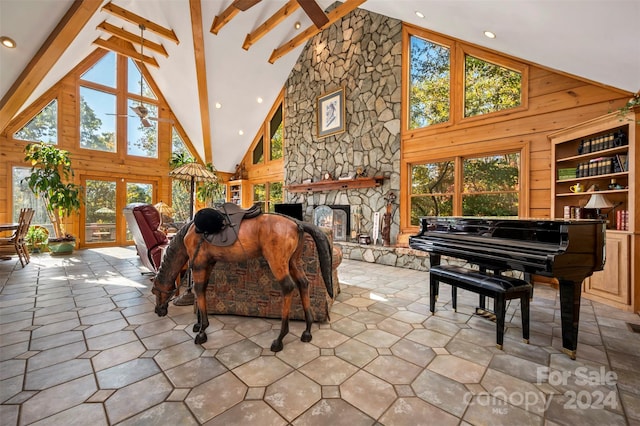 interior space with beamed ceiling, built in shelves, a fireplace, and high vaulted ceiling