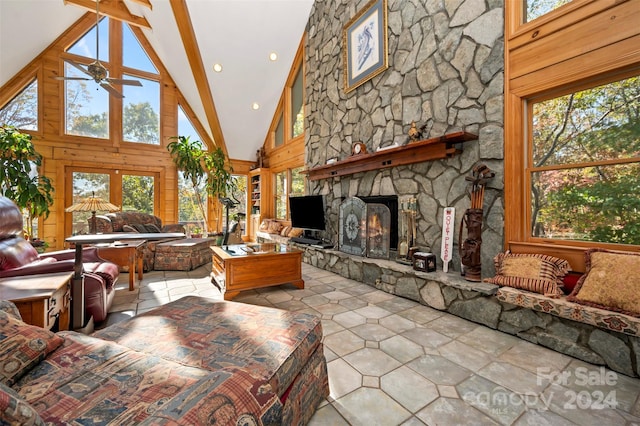 living room featuring beam ceiling, high vaulted ceiling, a fireplace, and ceiling fan