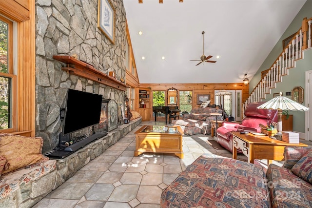 tiled living room with ceiling fan, high vaulted ceiling, and a fireplace