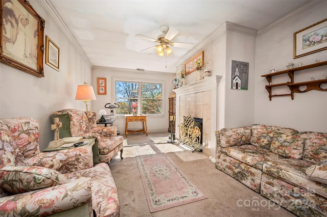 living room featuring a tiled fireplace, crown molding, light colored carpet, and ceiling fan