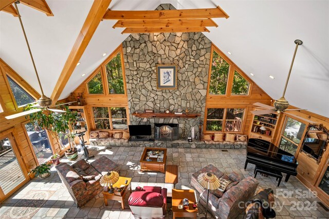 living room featuring beam ceiling, high vaulted ceiling, and a fireplace