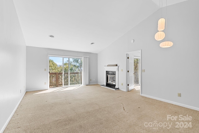 unfurnished living room with light colored carpet and high vaulted ceiling