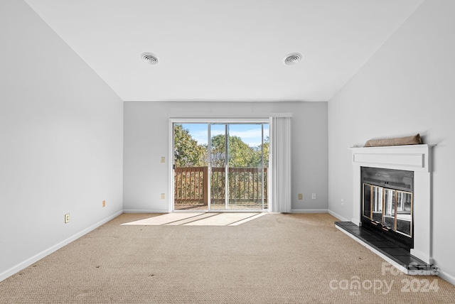 unfurnished living room featuring light colored carpet and vaulted ceiling