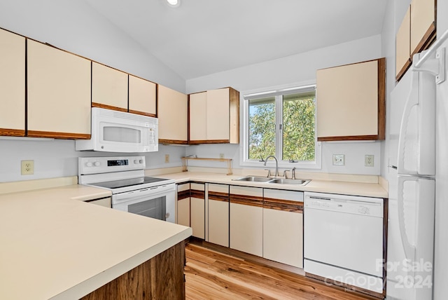 kitchen featuring white appliances, vaulted ceiling, sink, cream cabinetry, and light hardwood / wood-style floors