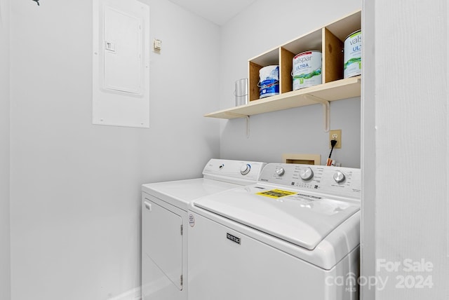 clothes washing area with washing machine and dryer and electric panel