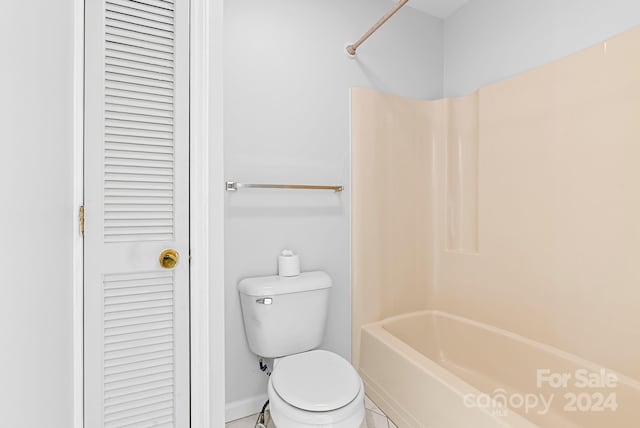 bathroom with tile patterned flooring, shower / bathtub combination, and toilet