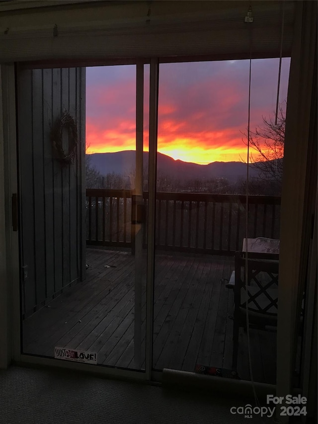 deck at dusk featuring a mountain view