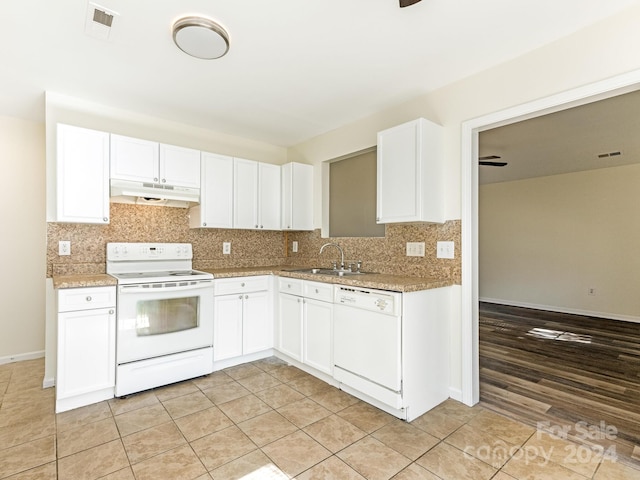 kitchen featuring decorative backsplash, white cabinetry, light tile patterned flooring, sink, and white appliances