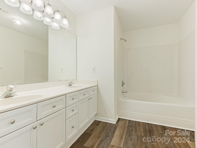 bathroom with vanity, wood-type flooring, and washtub / shower combination