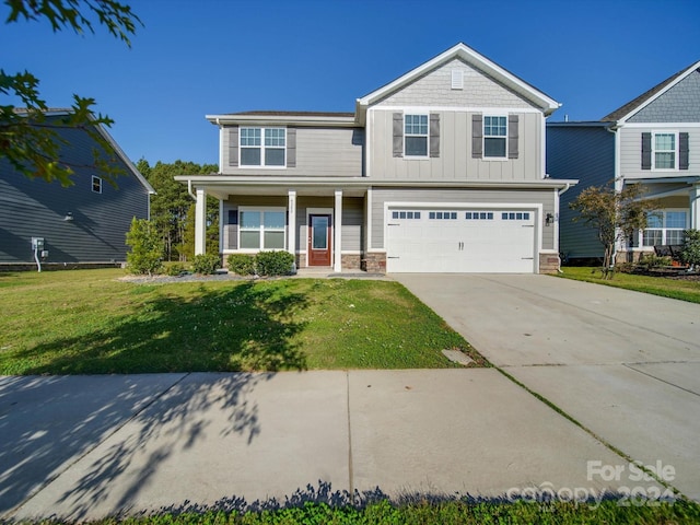 view of front of house with a front lawn, a garage, and a porch