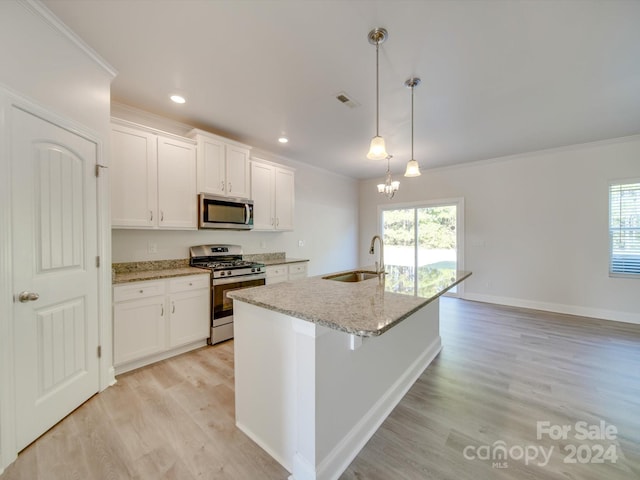 kitchen featuring a center island with sink, appliances with stainless steel finishes, pendant lighting, sink, and white cabinets