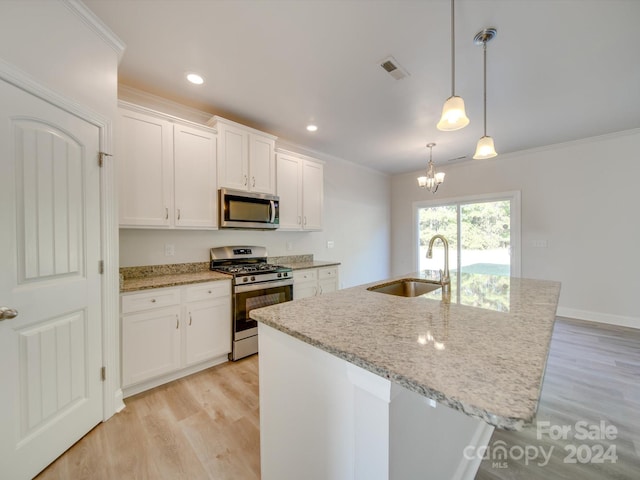 kitchen featuring stainless steel appliances, white cabinets, sink, and pendant lighting