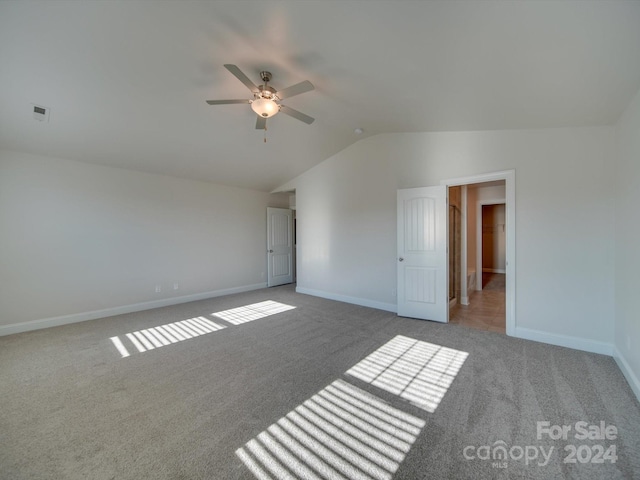 spare room featuring carpet, ceiling fan, and vaulted ceiling