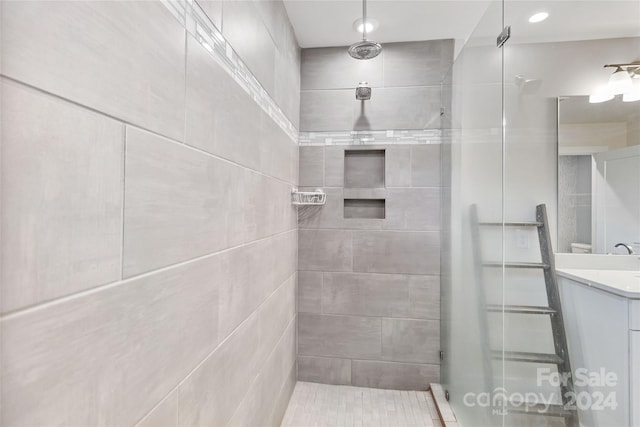 bathroom with vanity and tiled shower