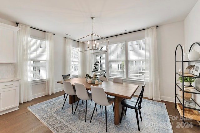 dining area featuring a chandelier and dark wood-type flooring