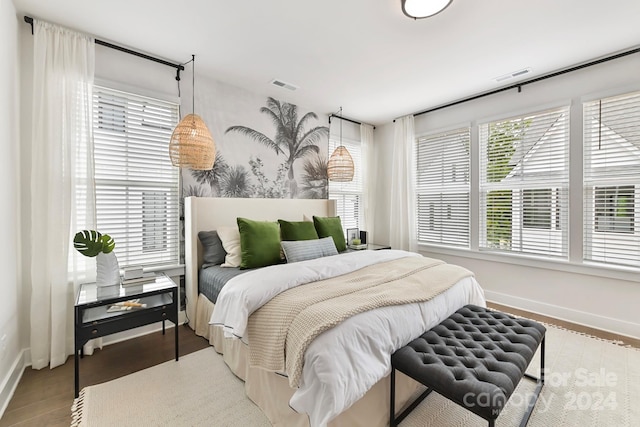 bedroom with hardwood / wood-style flooring and multiple windows