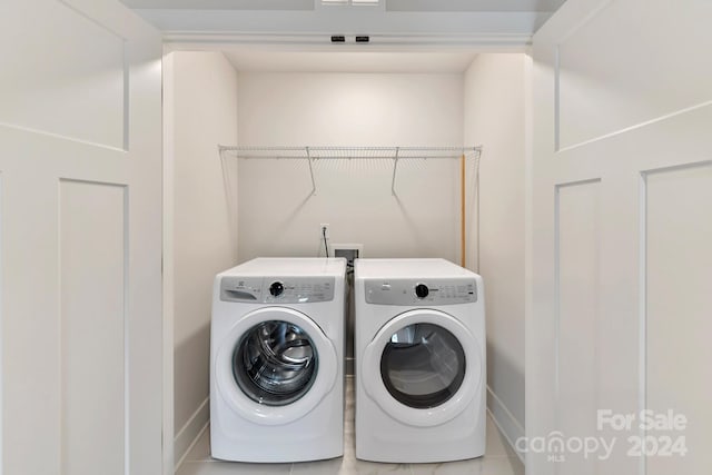 washroom with washing machine and dryer and tile patterned flooring