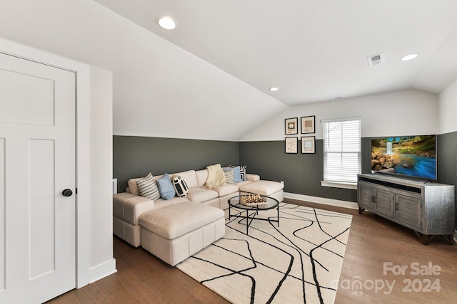 living room with hardwood / wood-style flooring and vaulted ceiling