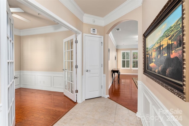 hall with ornamental molding and light wood-type flooring